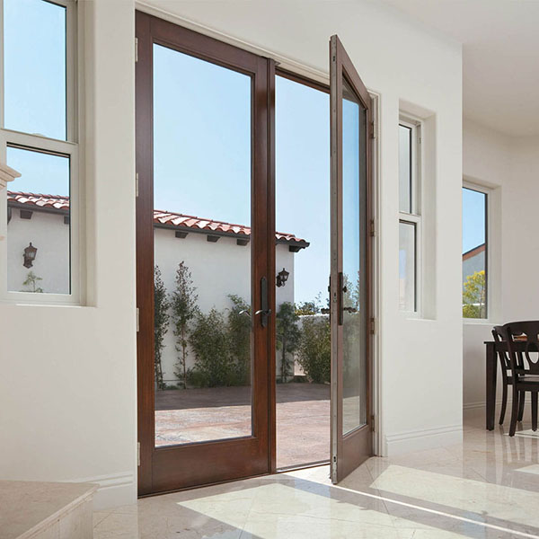 Interior of a home and close-up of a front door made of dark brown wood with one door opening up