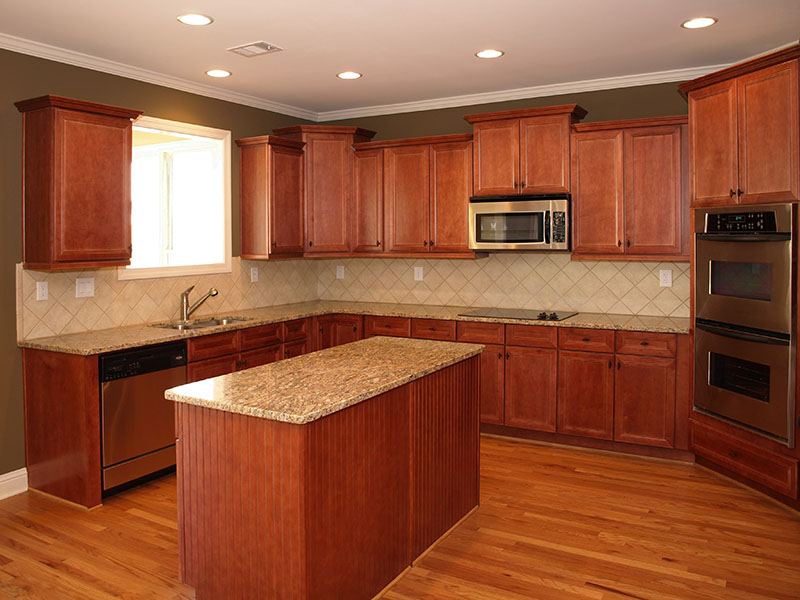 Modern looking kitchen with an island in the middle surrounded by beautiful looking brown wood cabinets