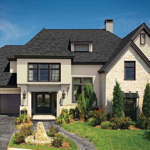 Front view of residential home with white siding and charcoal black GAF shingles on its roof